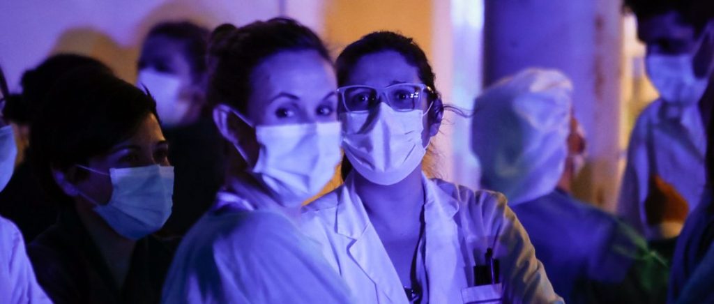 Medical staff and police thank each other for the work they do at Infanta Elena Hospital in Madrid on 27 March 2020.